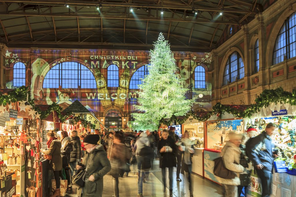Zurich, Switzerland - December 11, 2014: The Christmas market in the Central Station in Zurich hosts the largest indoor Christmas market in Europe with a large Christmas tree sparkling with over 7,000 Swarovski. People can stroll among stalls of gifts, crafts, sweets and mulled wine.